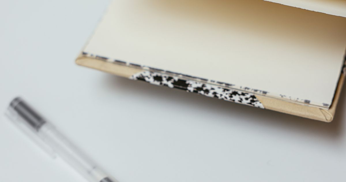 Open notebook and pen on a white surface